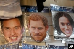 Masker bergambar Pangeran William kiri, Pangeran Harry, tengah, dan istrinya Meghan, kanan, terlihat dijual di sebuah toko di London, Jumat, 6 Januari 2023. (Foto: AP)