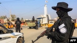 Seorang anggota pasukan keamanan Taliban berjaga di sebuah pos pemeriksaan di sepanjang jalan di Jalalabad, 6 Desember 2022. (AFP)