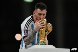 Argentina's captain and forward #10 Lionel Messi kisses the FIFA World Cup Trophy during the trophy ceremony after Argentina won the Qatar 2022 World Cup final football match between Argentina and France at Lusail Stadium in Lusail, north of Doha, Qatar, Dec. 18, 2022.