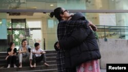 People react as they wait outside their homes after a tremor was felt in Mexico City, Mexico, Dec. 11, 2022. 