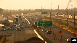 FILE - Cars and trucks roll along a section of Highway 99 during rush hour in Fresno, Calif., June 23, 2017. California's vast San Joaquin Valley has long been burdened by some of the nation's dirtiest air. 