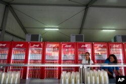 国际足联举办的第22届世界杯足球赛将于星期日（11月20日）在卡塔尔首都多哈市进行比赛。周六（11月19日），两位妇女正在为安放在球迷区自动啤酒贩售机补货。