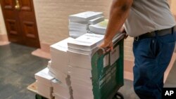 Stacks of the Congressional Record are distributed as lawmakers debate a $1.7 trillion federal spending bill, at the Capitol in Washington, Dec. 23, 2022. 