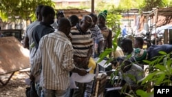 FILE - Men stand in line with their application letters to enroll as Volunteers for the Defense of the Fatherland (VDP), at the Governorate of Ouagadougou, Burkina Faso, Nov. 16, 2022.