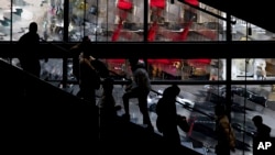 Shoppers walk up and down the stairs in a Nike store on Black Friday, Nov. 25, 2022, in New York.