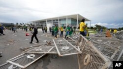 Para pengunjuk rasa, pendukung mantan Presiden Brasil Jair Bolsonaro, menyerbu Istana Planalto di Brasilia, Brasil, Minggu, 8 Januari 2023. (AP/Eraldo Peres)