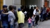 FILE - Hundreds of people overflow onto the sidewalk in a line snaking around the block outside a U.S. immigration office in San Francisco, Jan. 31, 2019.