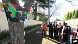 FILE - Chinese tourists stand outside former South African President Nelson Mandela's house in Johannesburg, South Africa, July, 2, 2013.