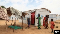 Children stand near a shelter at the Bogo IDP camp in Maroua, Cameroon, April 28, 2022. Cameroon is using this year's "Boxing Day," a day of giving following Christmas, to assist children displaced by the country's separatist conflict.
