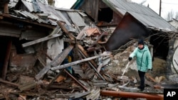 8일, 우크라이나 도네츠크 지역 쿠라코베에서 한 여성이 러시아군의 폭격으로 파괴된 집 주변을 살펴보고 있다.