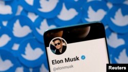 FILE Elon Musk's Twitter profile is seen on a smartphone placed on printed Twitter logos in this picture illustration taken Apr. 28, 2022. 