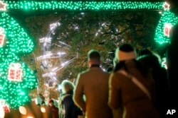 Para pengunjung berjalan di Wiener Chritkindlmarkt, salah satu pasar Natal paling populer di Wina, Austria, Sabtu, 19 November 2022. (AP/Michael Gruber)