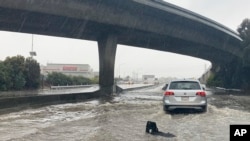 Traffic drives through flooded lanes on Highway 101 in South San Francisco, California, Dec. 31, 2022. A flood watch is in effect across much of Northern California through New Year's Eve. 