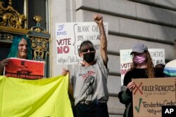 Denise Dorey, middle, reacts to speakers while taking part in a demonstration about the use of robots by the San Francisco Police Department outside of City Hall in San Francisco, Monday, Dec. 5, 2022. (AP Photo/Jeff Chiu, File)