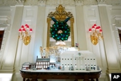 A sugar cookie replica of Independence Hall and a gingerbread replica of the White House are on display in the State Dining Room of the White House during a press preview of holiday decorations at the White House, in Washington, Nov. 28, 2022.