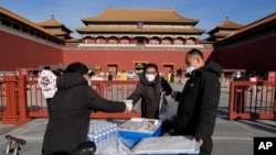 Para petugas mengirimkan makanan bagi para pekerja di area Forbidden City di Beijing, pada 14 Desember 2022. (Foto: AP/Ng Han Guan)