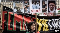 A demonstrator holds portraits of Iranian protesters who were executed in Iran, during a rally in Lyon, France, Jan. 8, 2023 against the Iranian regime.