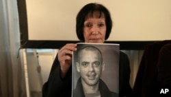Denise Guidoux holds a photo of her son, Salah Hammouri, a French-Palestinian lawyer who is set to be deported to France, at a press conference in east Jerusalem, Dec. 2, 2022. 