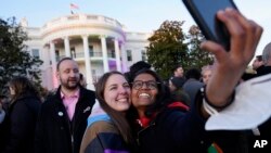 Aparna Shrivastava, right, and Shelby Teeter snap a photo after President Joe Biden signed the Respect for Marriage Act, Dec. 13, 2022.