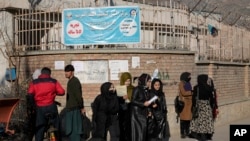 Mahasiswa perempuan Afghanistan berdiri di luar Universitas Kabul di Kabul, Afghanistan, Rabu, 21 Desember 2022. (Foto: AP)