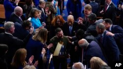 Ukrainian President Volodymyr Zelenskyy holds an American flag gifted to him by U.S. House Speaker Nancy Pelosi, as he leaves after addressing a joint meeting of Congress on Capitol Hill in Washington, Dec. 21, 2022.