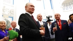 Russian President Vladimir Putin toasts at an awarding ceremony at the Kremlin's St. Catherine Hall in Moscow, Russia, Dec. 20, 2022.