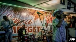 JC Kibombo, un musicien de renom, chante avec son groupe musical sur le podium d'un bar devant un public dansant sur sa musique à Goma, dans l'est de la RDC, le 20 novembre 2022.