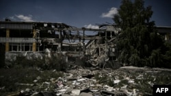 A photograph taken on June 8, 2022 shows books scattered outside a school destroyed after a strike in Bakhmut, eastern Ukrainian region of Donbas.