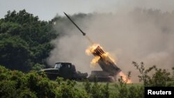 Anggota pasukan Ukraina menembakkan sistem peluncuran roket ganda BM-21 Grad, dekat kota Lysychansk, wilayah Luhansk, di tengah serangan Rusia ke Ukraina, 12 Juni 2022. (REUTERS/Gleb Garanich)