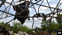 People clean an area of a building damaged by an overnight missile strike in Sloviansk, Ukraine, June 1, 2022.