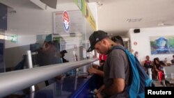 Seorang migran tampak membeli tiket bus di sebuah terminal di Huixtla, Meksiko, pada 10 Juni 2022. (Foto: Reuters/Quetzalli Nicte-Ha)