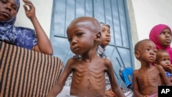Seorang anak laki-laki berusia dua tahun yang kekurangan gizi duduk di sebelah ibunya (kiri), di sebuah pusat malnutrisi yang dikelola oleh Action Against Hunger, di Mogadishu, Somalia, pada 5 Juni 2022. (AP/Farah Abdi Warsameh)