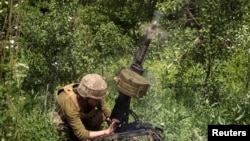 Seorang anggota pasukan Ukraina menembakkan peluncur granat otomatis di garis depan dalam pertempuran melawan pasukan Rusia di dekat Bakhmut, wilayah Donbas, Ukraina, pada 5 Juni 2022. (Foto: Reuters/Gleb Garanich)