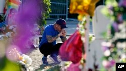 Seorang pria memberikan penghormatannya di sebuah peringatan di luar Robb Elementary School, 2 Juni 2022, di Uvalde, Texas, untuk menghormati para korban yang tewas dalam penembakan di sekolah pada 24 Mei. (Foto: AP)