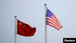 Bendera AS dan China dipasang di luar sebuah gedung perusahaan di Shanghai, China, pada 14 April 2021. (Foto: Reuters/Aly Song)