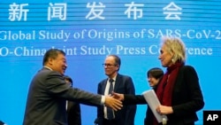 FILE: Marion Koopmans (R) and Peter Ben Embarek (C), of the World Health Organization team say farewell to their Chinese counterpart Liang Wannian, (L), after a WHO-China Joint Study Press Conference at the end of the WHO mission in Wuhan, China, Feb 9, 2021.