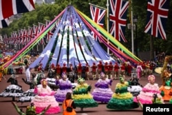 Para penari yang mengenakan kostum mengambil bagian dalam parade selama Kontes Platinum Jubilee di London, 5 Juni 2022.