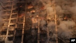 Ukrainian firefighters work at a bombed apartment building in Kyiv, Ukraine, Tuesday, March 15, 2022.