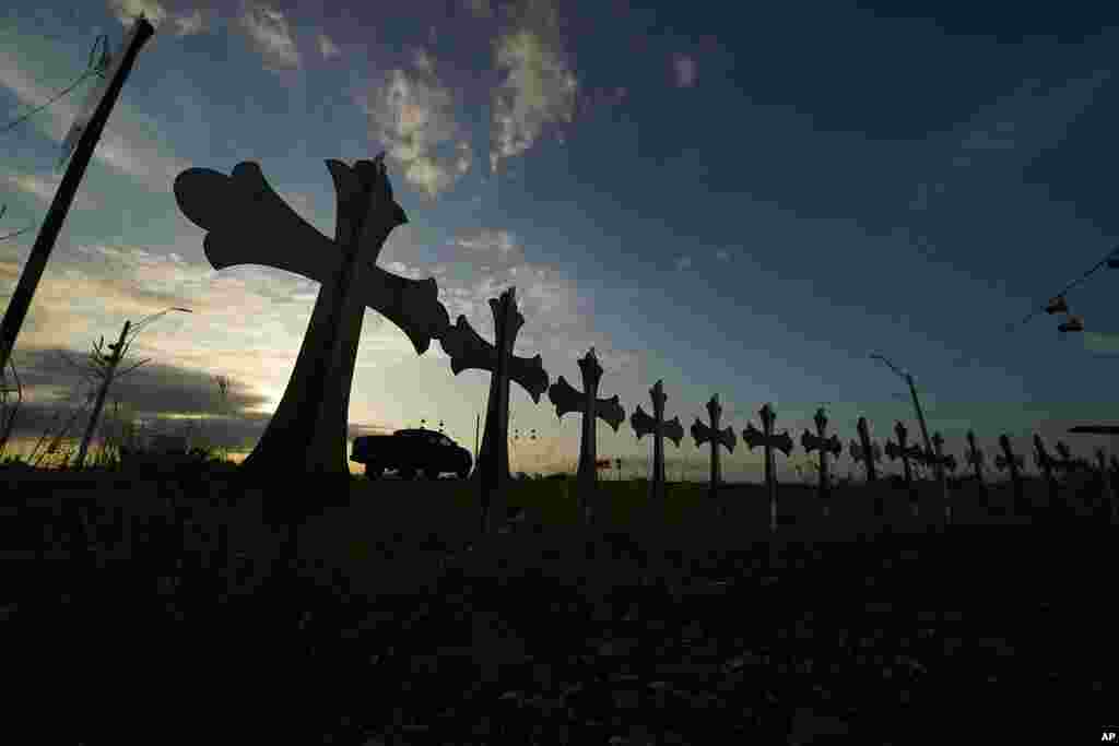 A truck passes crosses placed to honor the victims killed in last week's shooting at Robb Elementary School, in Uvalde, Texas.