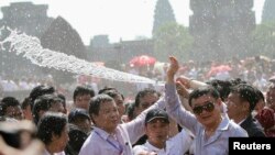 លោក Thaksin Shinawatra អតីត​នាយករដ្ឋមន្ត្រី​ថៃ​បក់ដៃ​ទៅ​កាន់​អ្នក​គាំទ្រ​​ខណៈ​ដែល​ពួក​គេ​ត្រូវ​បាន​គេ​បាញ់​ទឹក​ប្រសិទ្ធពរ​នៅ​ក្នុង​ថ្ងៃ​ចុងក្រោយ​នៃ​ពិធី​បុណ្យ​ចូល​ឆ្នាំ​ខ្មែរ​​និង​ថៃ​នៅ​ប្រាសាទ​អង្គរវត្ត​ខេត្ត​សៀមរាប កាល​ពី​ថ្ងៃ​ទី​១៥ ខែ​មេសា ឆ្នាំ​២០១២។