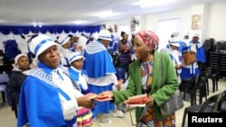 Faithful hand out pamphlets on coronavirus disease (COVID-19) at the end of service, at the Apostolic Christian Church in Kagiso, west of Johannesburg, South Africa, March 22, 2020.