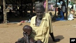 Sudanese man holds malnourished grandson at Medicine Sans Frontieres feeding center, Sept. 2005 (file photo).