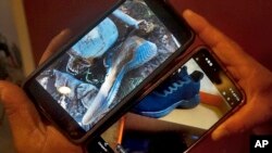 Oscar Andrade, who heads a group that provides recovery efforts for families of missing migrants, compares his photo of a worn shoe next to a human skull, top, with a photo of the same brand of shoe sent by a relative of a missing Mexican migrant, Sept. 6, 2022, in Tucson, Ariz.