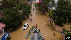 Warga melewati jalan yang terendam banjir akibat Topan Noru di Kota San Miguel, Provinsi Bulacan, Filipina, 26 September 2022. (Foto: AP)