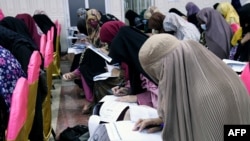 FILE - Bburqa-clad Afghan women take an entrance test at Mamon Tahiri institute in Kandahar, Afghanistan.