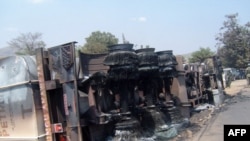 L'épave incendiée d'un pétrolier repose sur le flanc à la suite d'une explosion à Sange, en République démocratique du Congo, le 3 juillet 2010. (VOA/Archives)