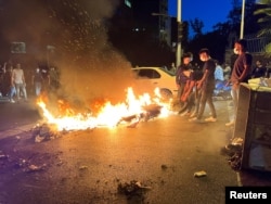 FILE - A police motorcycle burns during a protest over the death of Mahsa Amini, a woman who died after being arrested by the Islamic republic's morality police in Tehran, Iran, Sept. 19, 2022. (West Asia News Agency via Reuters)
