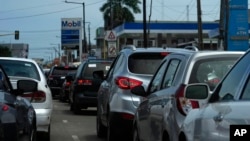 FILE - Cars line up outside a petrol station in Lagos, Nigeria, June 22, 2022. 
