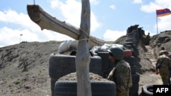FILE - A soldier stands at a border check point between Armenia and Azerbaijan near the village of Sotk, Armenia, June 18, 2021.
