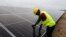 FILE - A technician works on solar power panels at the Atlantic Shrimpers farm in Badagry, Lagos, Nigeria, July 5, 2022. 